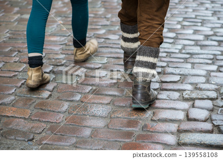 People Walking On Wet Cobblestone Street In Urban Scene People Walking On Wet Cobblestone Street In Urban Scene 139558108