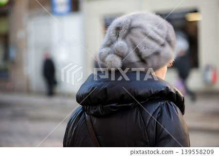 Elderly woman in winter clothing on city street Elderly woman in winter clothing on city street 139558209