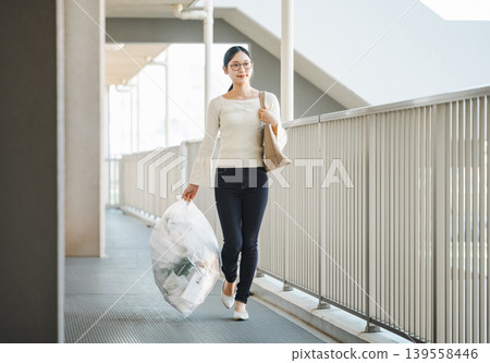 A woman taking out the trash on her way to work in the morning. 139558446