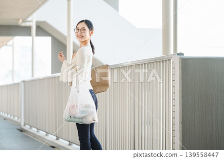 一位年輕女子購物後返回公寓的肖像。 139558447