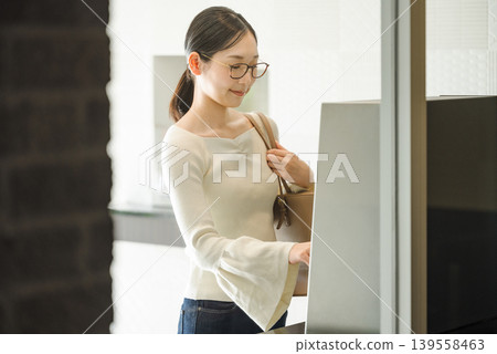一名年輕女子正在操作公寓大樓的自動計時器。 一名年輕女子正在操作公寓大樓的自動計時器。 139558463