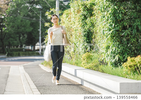 走在一個住宅區的年輕女子 走在一個住宅區的年輕女子 139558466