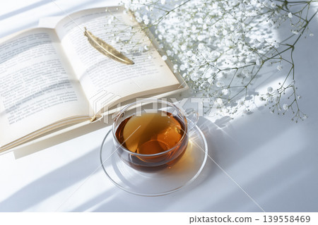 Morning reading time in the sunlight, tea, and baby's breath Morning reading time in the sunlight, tea, and baby's breath 139558469