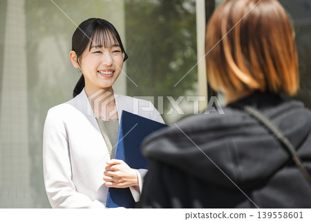 A young career woman working in real estate sales explains something to a client. 139558601
