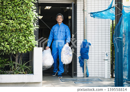 一位公寓大樓的高級男性管理員正在倒垃圾 139558814