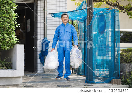 A senior male apartment building manager taking out the trash 139558815