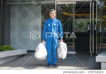 一位公寓大樓的高級男性管理員正在倒垃圾 一位公寓大樓的高級男性管理員正在倒垃圾 139558820