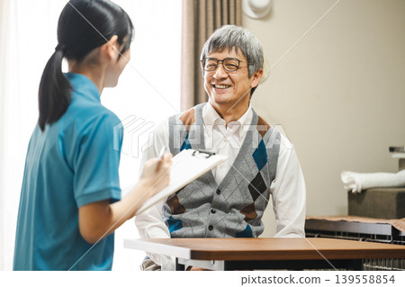 A senior male resident talking to a caregiver. A senior male resident talking to a caregiver. 139558854