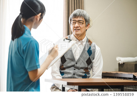 一位老年男性使用者正在諮詢護理人員。 139558859