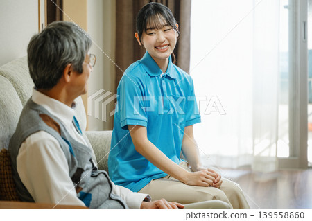 一位女家政服務生正在客戶家中與客戶交談。 139558860