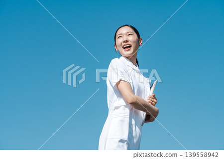 A young nurse wearing a white coat A young nurse wearing a white coat 139558942