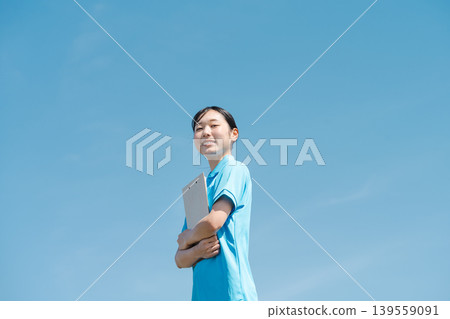 A portrait of a young female caregiver standing under a blue sky. A portrait of a young female caregiver standing under a blue sky. 139559091