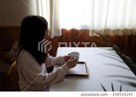 一位身穿家居服、頭髮隨意披散的女士正在喝熱水——這是她慢慢進入清晨節奏的畫面。 一位身穿家居服、頭髮隨意披散的女士正在喝熱水——這是她慢慢進入清晨節奏的畫面。 139559145