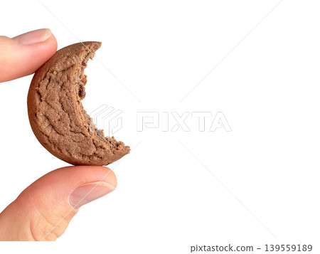 Fingers holding bitten chocolate chip cookie crescent moon Fingers holding bitten chocolate chip cookie crescent moon 139559189