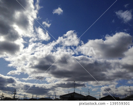 Powerful cumulus clouds and a vibrant blue sky stretching above a Japanese residential area. Powerful cumulus clouds and a vibrant blue sky stretching above a Japanese residential area. 139559301