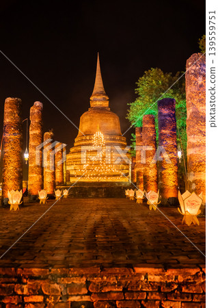 Light Buddha image on ancient pagoda during Loy Krathong festival in Sukhothai historical park, Thailand. Light Buddha image on ancient pagoda during Loy Krathong festival in Sukhothai historical park, Thailand. 139559751