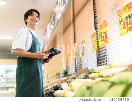A male employee operates a tablet. A male employee operates a tablet. 139559780