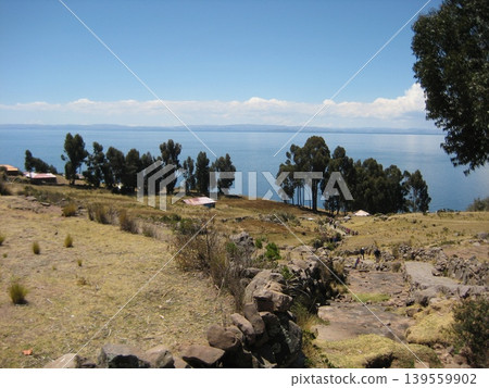 A view of Taquile Island overlooking Lake Titicaca from a stone-walled road. A view of Taquile Island overlooking Lake Titicaca from a stone-walled road. 139559902