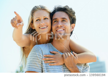 Pointing, love or happy couple hug on outdoor date for support or love in summer in nature together. Relax, romantic man or woman talking with smile on holiday vacation for bond, travel or wellness 139560194