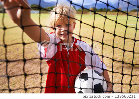 Girl, soccer player and ball on goal net, smile and happy for game, field and child. Outdoor, playful and sport for childhood, portrait and athlete for match, alone and outside on football pitch Girl, soccer player and ball on goal net, smile and happy for game, field and child. Outdoor, playful and sport for childhood, portrait and athlete for match, alone and outside on football pitch 139560231