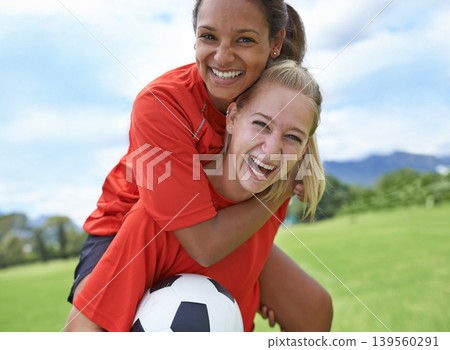 Happy woman, friends and piggyback with soccer ball on green grass for winning, achievement or sports in nature. Portrait of female person or football player smile for hug, match or game on field Happy woman, friends and piggyback with soccer ball on green grass for winning, achievement or sports in nature. Portrait of female person or football player smile for hug, match or game on field 139560291