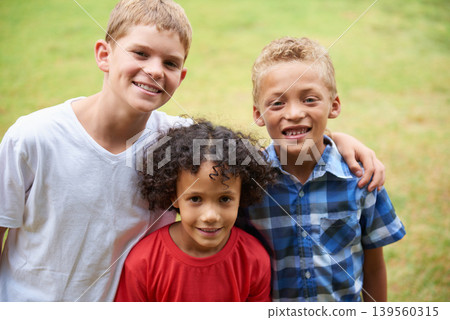 Boys, friends and portrait or happy on field in summer with confidence, pride or diversity in nature. Children, face or smile on grass with embrace for friendship, care and support on playground 139560315