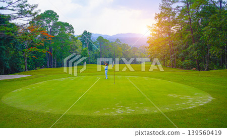 Golfers are putting golf in the evening golf course golf backglound. Golfers are putting golf in the evening golf course golf backglound. 139560419