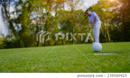 Golfers are putting golf in the evening golf course golf backglound. Golfers are putting golf in the evening golf course golf backglound. 139560425