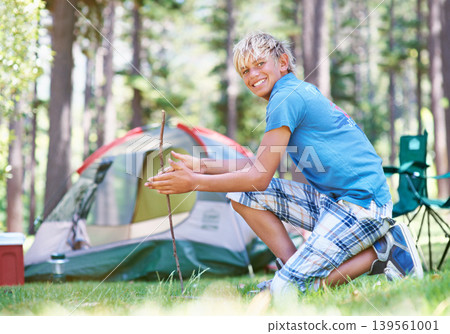 Start, campfire or portrait of boy in woods for summer camp, survival education or learning. Kid, spark or happy male child on adventure with sticks or smile in nature on holiday vacation in forest Start, campfire or portrait of boy in woods for summer camp, survival education or learning. Kid, spark or happy male child on adventure with sticks or smile in nature on holiday vacation in forest 139561001