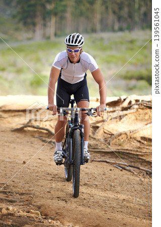 Action, race and man cycling in nature training for a competition on trail in forest or woods. Terrain, sports or fast cyclist athlete riding bicycle at speed for cardio exercise, fitness or workout Action, race and man cycling in nature training for a competition on trail in forest or woods. Terrain, sports or fast cyclist athlete riding bicycle at speed for cardio exercise, fitness or workout 139561045