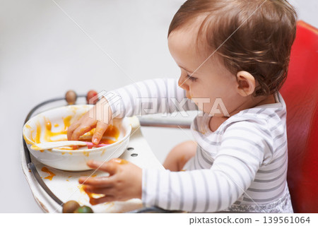 Eating, puree and girl baby in chair with vegetable food for child development at home. Cute, nutrition and hungry young kid or toddler enjoying healthy lunch, dinner or supper meal at house. Eating, puree and girl baby in chair with vegetable food for child development at home. Cute, nutrition and hungry young kid or toddler enjoying healthy lunch, dinner or supper meal at house. 139561064