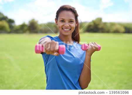 Woman, portrait and dumbbell, weightlifting for fitness and muscle, athlete outdoor for sport and strength. Healthy, exercise equipment and strong in park with weights and workout with a smile Woman, portrait and dumbbell, weightlifting for fitness and muscle, athlete outdoor for sport and strength. Healthy, exercise equipment and strong in park with weights and workout with a smile 139561096