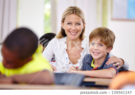 Teacher woman, classroom and help boy at desk in portrait with support, advice or knowledge for education. People, learning and development for person, child and happy for progress, school or academy Teacher woman, classroom and help boy at desk in portrait with support, advice or knowledge for education. People, learning and development for person, child and happy for progress, school or academy 139561147