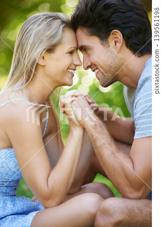 Couple, forehead touch and smile in park with love and commitment in healthy relationship. People on date outdoor, happiness and care with trust, holding hands and bonding together for marriage Couple, forehead touch and smile in park with love and commitment in healthy relationship. People on date outdoor, happiness and care with trust, holding hands and bonding together for marriage 139561198