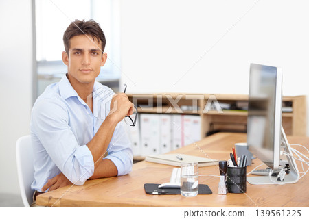 Office, portrait or employee with computer at desk with technology for project or solution. IT support, business or serious man programming with glasses or research online at workplace or workspace Office, portrait or employee with computer at desk with technology for project or solution. IT support, business or serious man programming with glasses or research online at workplace or workspace 139561225