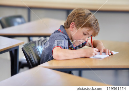 Boy, notebook and writing in school, classroom or studying academic assessment, learning lesson or test at table. Student, child and kid drawing notes on paper for education, development or knowledge Boy, notebook and writing in school, classroom or studying academic assessment, learning lesson or test at table. Student, child and kid drawing notes on paper for education, development or knowledge 139561354