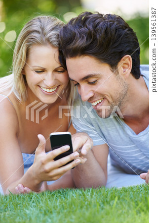Grass, phone or happy couple on social media in nature to relax together on outdoor holiday vacation. Smile, woman or man with funny meme or online post for bond with love, support or care on field Grass, phone or happy couple on social media in nature to relax together on outdoor holiday vacation. Smile, woman or man with funny meme or online post for bond with love, support or care on field 139561387