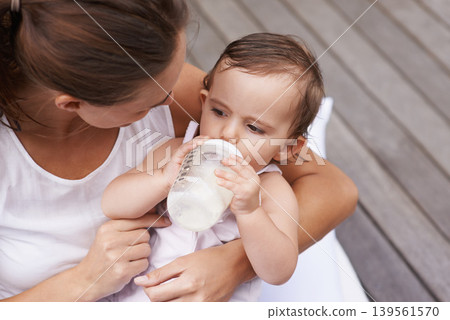 Baby, mother and drinking formula for nutrition, food and relaxing together on porch at home. Mommy, toddler and bottle for health or child development in outdoors, feeding and milk for wellness Baby, mother and drinking formula for nutrition, food and relaxing together on porch at home. Mommy, toddler and bottle for health or child development in outdoors, feeding and milk for wellness 139561570