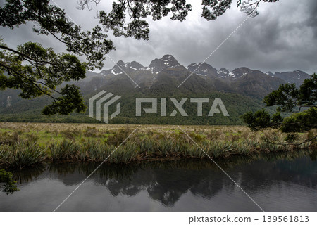 Dramatic cloudy sky over Earl Mountains and Mirror Lakes, Fiordland National Park, New Zealand. Dramatic cloudy sky over Earl Mountains and Mirror Lakes, Fiordland National Park, New Zealand. 139561813