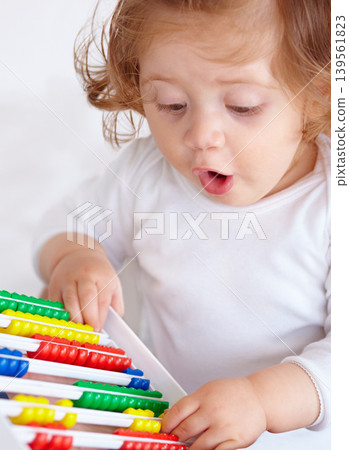 Abacus, surprise and girl baby learning, playing and teaching for child development on bed. Maths, toy and closeup of young kid, infant or toddler counting for education in bedroom at modern home. Abacus, surprise and girl baby learning, playing and teaching for child development on bed. Maths, toy and closeup of young kid, infant or toddler counting for education in bedroom at modern home. 139561823