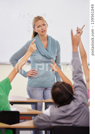 Teacher woman, children group and raised hand in classroom for question, answer or pop quiz with stress. Teaching person, school kids and education with frustrated face, talking or lecture at academy Teacher woman, children group and raised hand in classroom for question, answer or pop quiz with stress. Teaching person, school kids and education with frustrated face, talking or lecture at academy 139561849