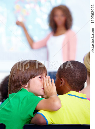 Little boys, whisper and classroom in ear at classroom for secret, gossip or communication at school. Male person, students or friends listening to rumor or surprise in class together with teacher Little boys, whisper and classroom in ear at classroom for secret, gossip or communication at school. Male person, students or friends listening to rumor or surprise in class together with teacher 139562061