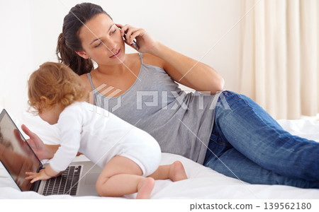 Working, mom and phone call with baby on laptop multitasking in home. Infant, kid and mother busy with computer and smartphone for remote work, productivity and online communication in bedroom Working, mom and phone call with baby on laptop multitasking in home. Infant, kid and mother busy with computer and smartphone for remote work, productivity and online communication in bedroom 139562180