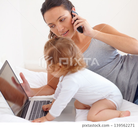 Working, phone call and mom with baby on laptop multitasking in home. Infant, kid and mother busy with computer and smartphone for remote work, productivity and online communication in bedroom 139562271