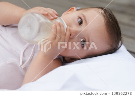 Baby, kid and drinking bottle for nutrition, liquid food and relaxing together on porch at home. Girl, toddler and formula for health or child development in outdoors, feeding and milk for wellness Baby, kid and drinking bottle for nutrition, liquid food and relaxing together on porch at home. Girl, toddler and formula for health or child development in outdoors, feeding and milk for wellness 139562278