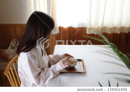 A woman eating granola for breakfast A woman eating granola for breakfast 139562409