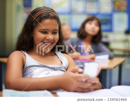 School, students or girl with a phone for texting, gossip or message notification in classroom. News, sharing or happy child with a funny meme on mobile app or social media for online distraction School, students or girl with a phone for texting, gossip or message notification in classroom. News, sharing or happy child with a funny meme on mobile app or social media for online distraction 139562460