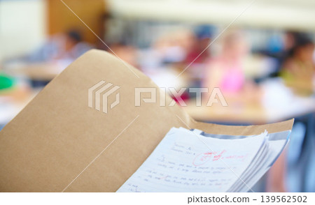 Classroom, test papers and marks for exams, school and files for students, results and folder. Closeup, academic and education for grading, childhood and person for assignments, scholar and reports 139562502