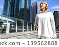 A woman with a laptop walking through the office district of Shimbashi. 139562888