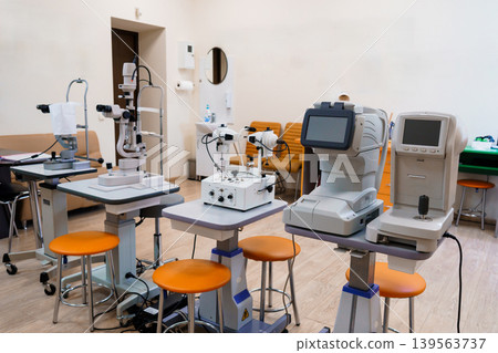 Ophthalmology clinic interior with medical equipment, eye exam tools, optometry devices, modern design, beige and orange Ophthalmology clinic interior with medical equipment, eye exam tools, optometry devices, modern design, beige and orange 139563737